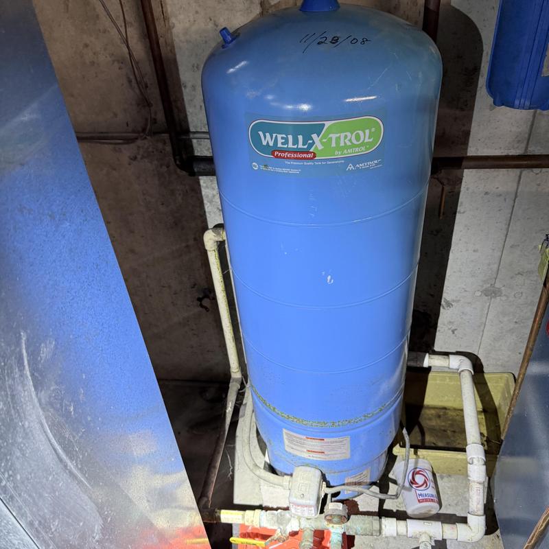 Well tank with connected piping in basement setup