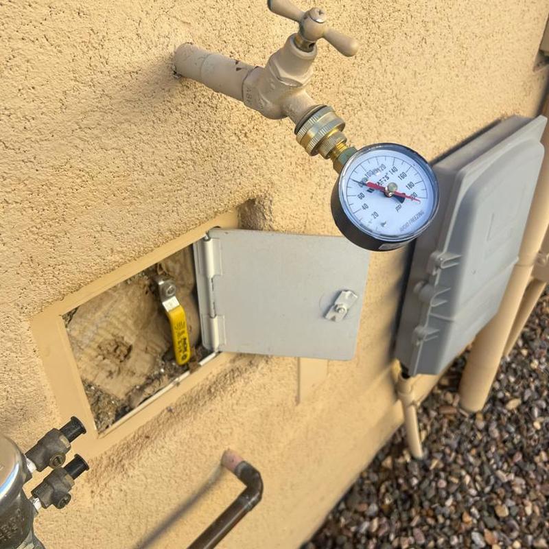 Hose bib with pressure gauge on exterior wall