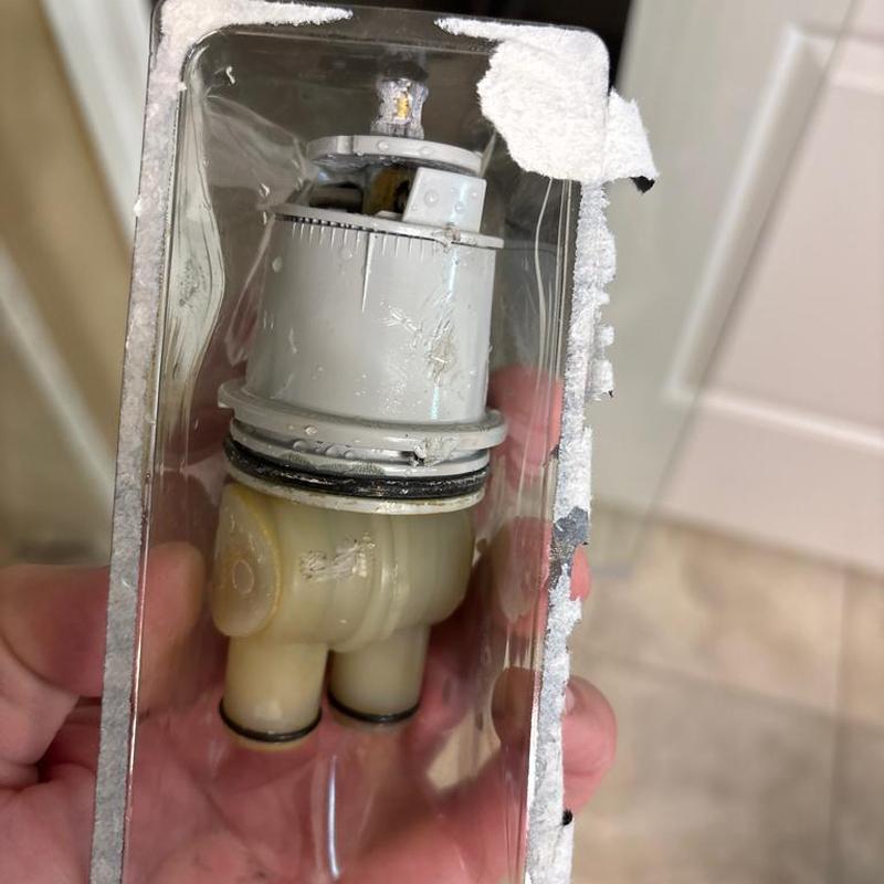 Shower cartridge held in hand after replacement