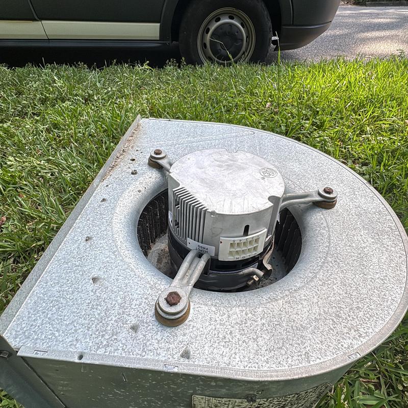 HVAC blower motor outside unit in grass