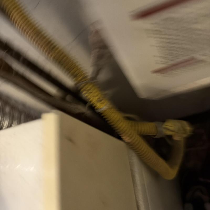 Yellow corrugated gas pipe connection to furnace unit