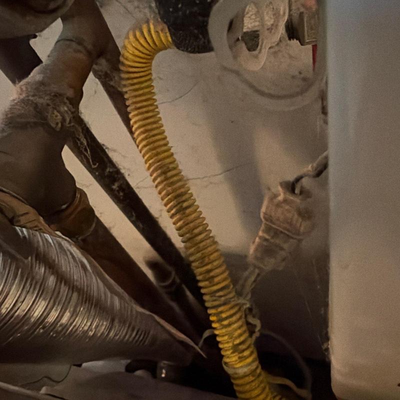 Yellow corrugated gas line near water heater valve