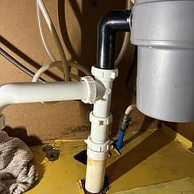 Kitchen drain piping under sink near garbage disposal