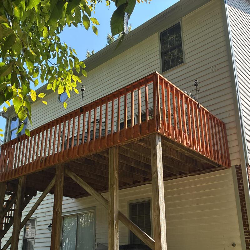 Tall wooden deck with railing on house exterior