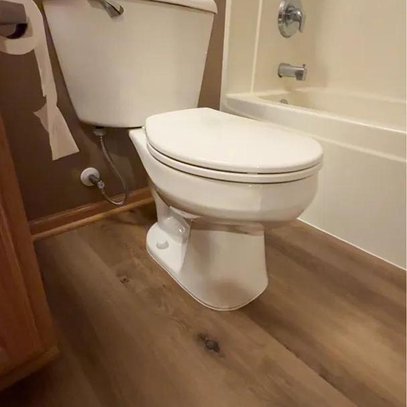 Toilet reinstalled on new wood flooring in bathroom