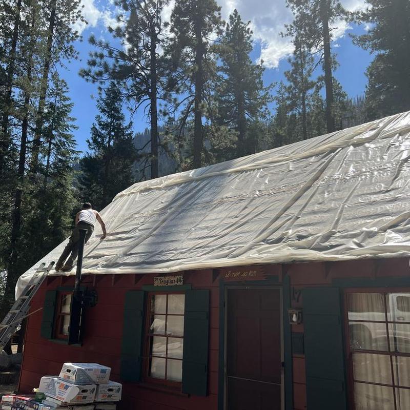 Asphalt roof under protective plastic cover on cabin Asphalt roof under protective plastic cover on cabin