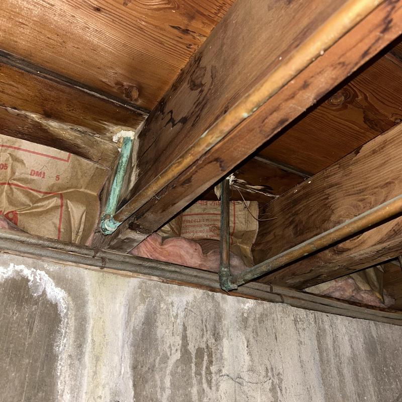 Copper water supply pipes under floor joists with corrosion Copper water supply pipes under floor joists with corrosion