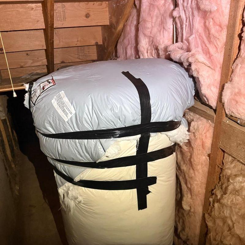 Insulation bag wrapped with black tape in attic space Insulation bag wrapped with black tape in attic space