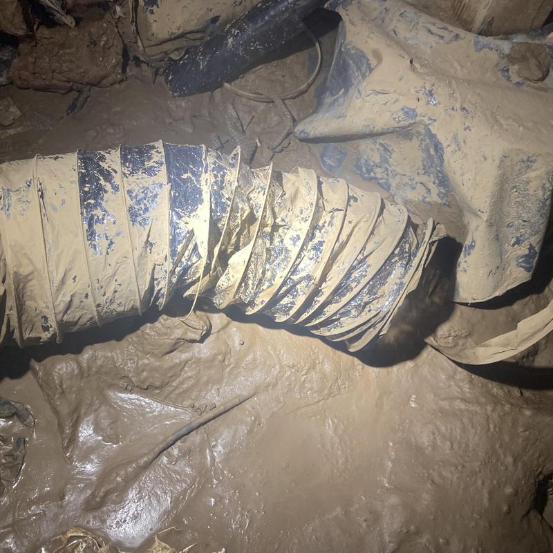 Flexible ductwork covered in mud in flooded crawlspace