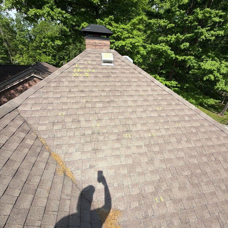 Roof shingles with hail damage marked for repair