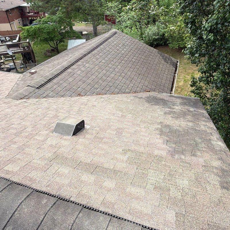 Asphalt shingle roof with visible wear and discoloration
