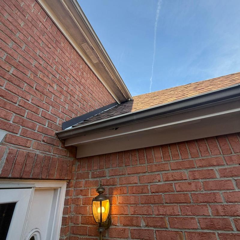 Asphalt shingle roof with gutter and brick wall