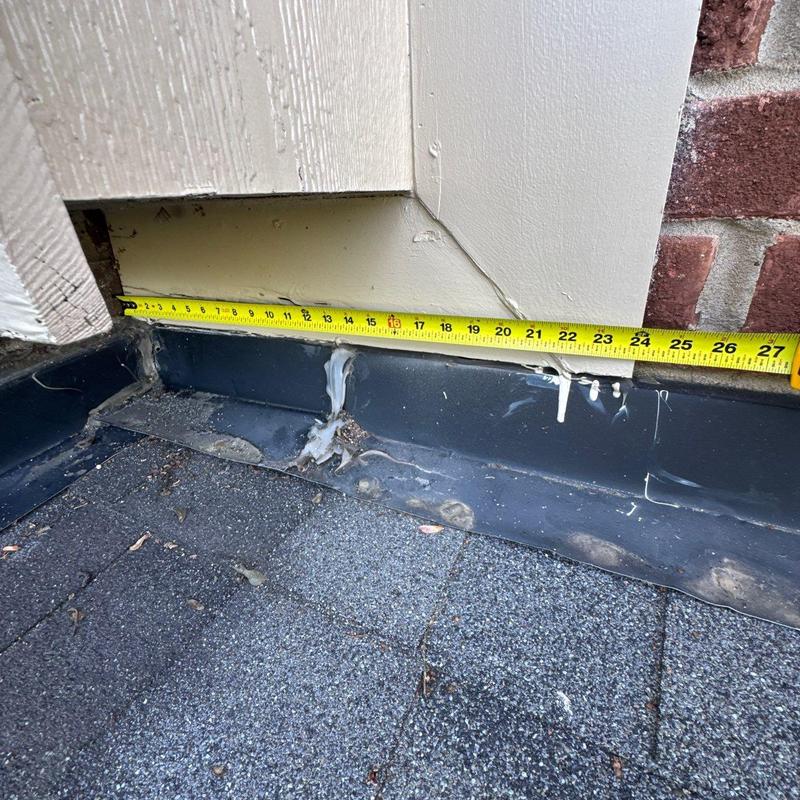Roof flashing with measurement tape on shingle roof edge