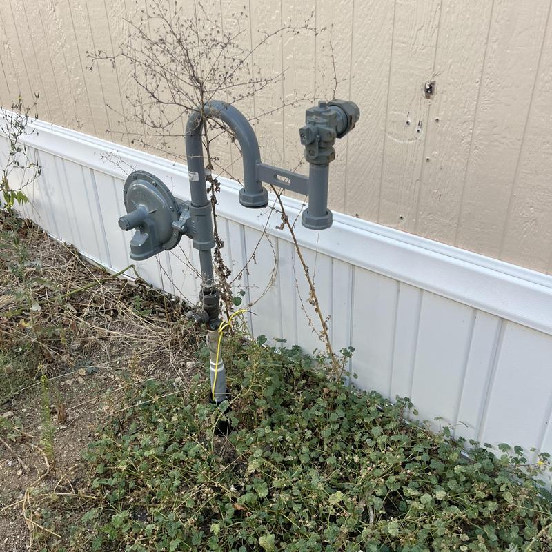 Gas meter and regulator near mobile home wall