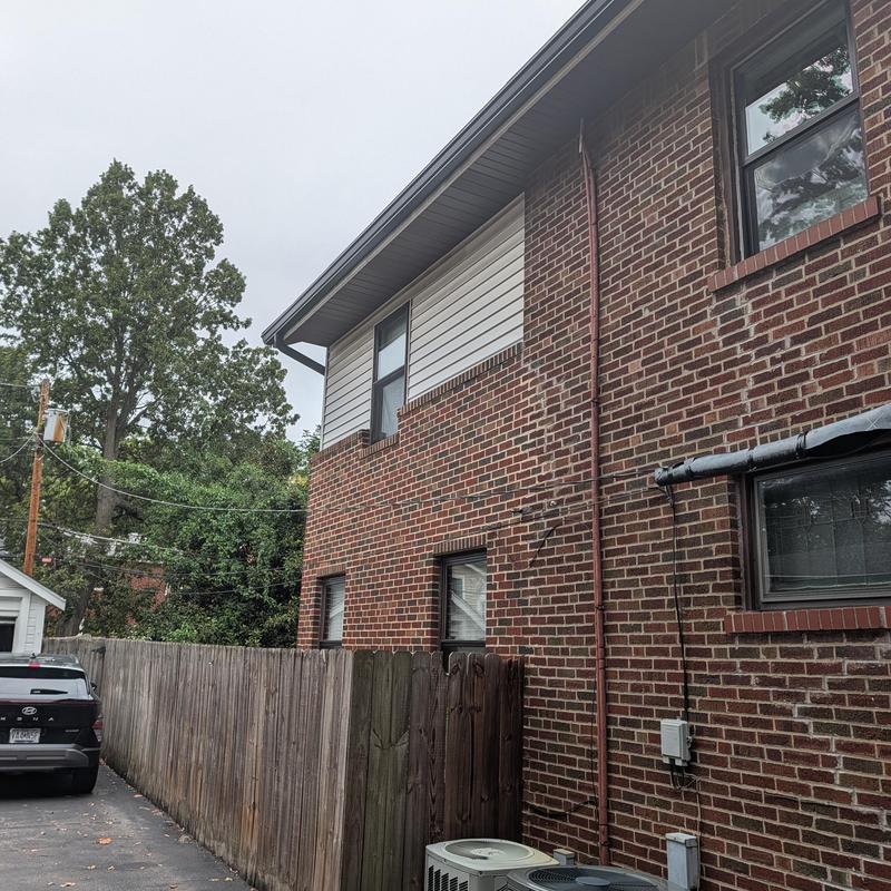 Brick wall and vinyl siding with window replacements