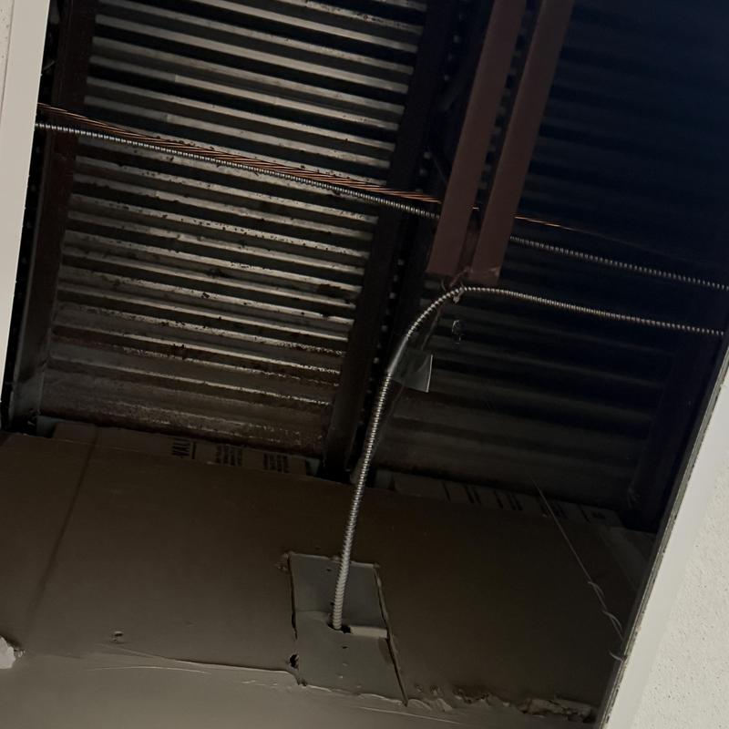 Exposed ceiling with electrical conduit and metal beams Exposed ceiling with electrical conduit and metal beams