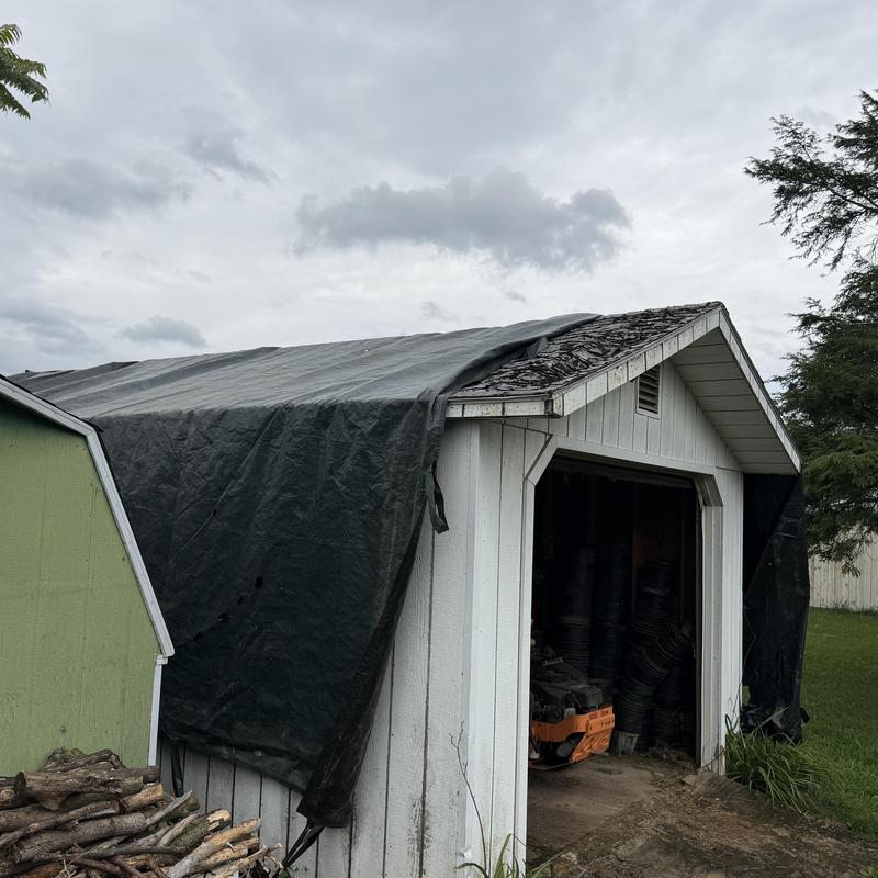 Asphalt shingle roof with tarp covering storm damage Asphalt shingle roof with tarp covering storm damage