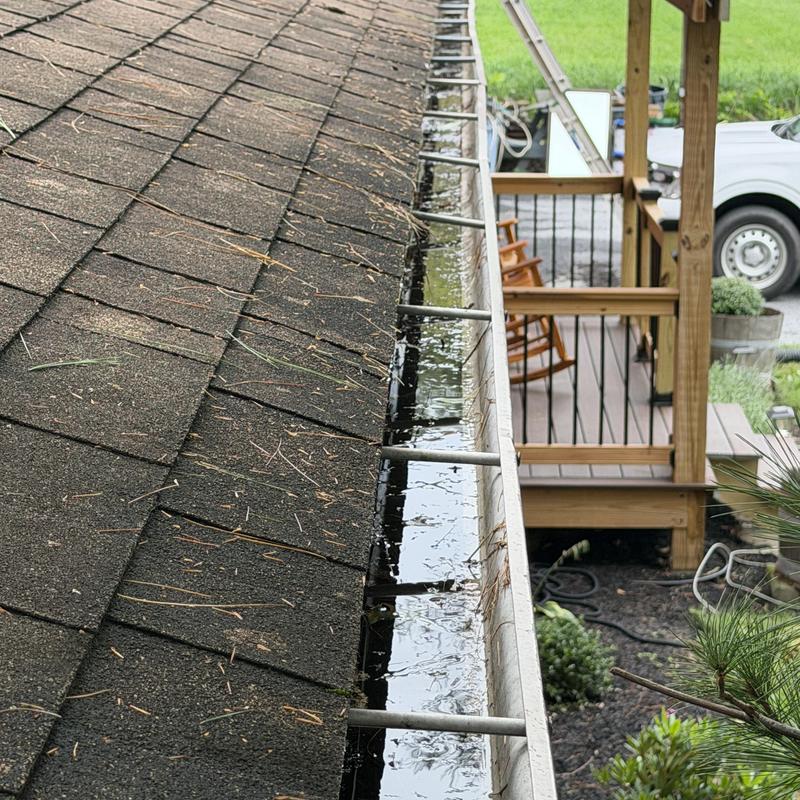 Gutter clogged with standing water on shingle roof Gutter clogged with standing water on shingle roof
