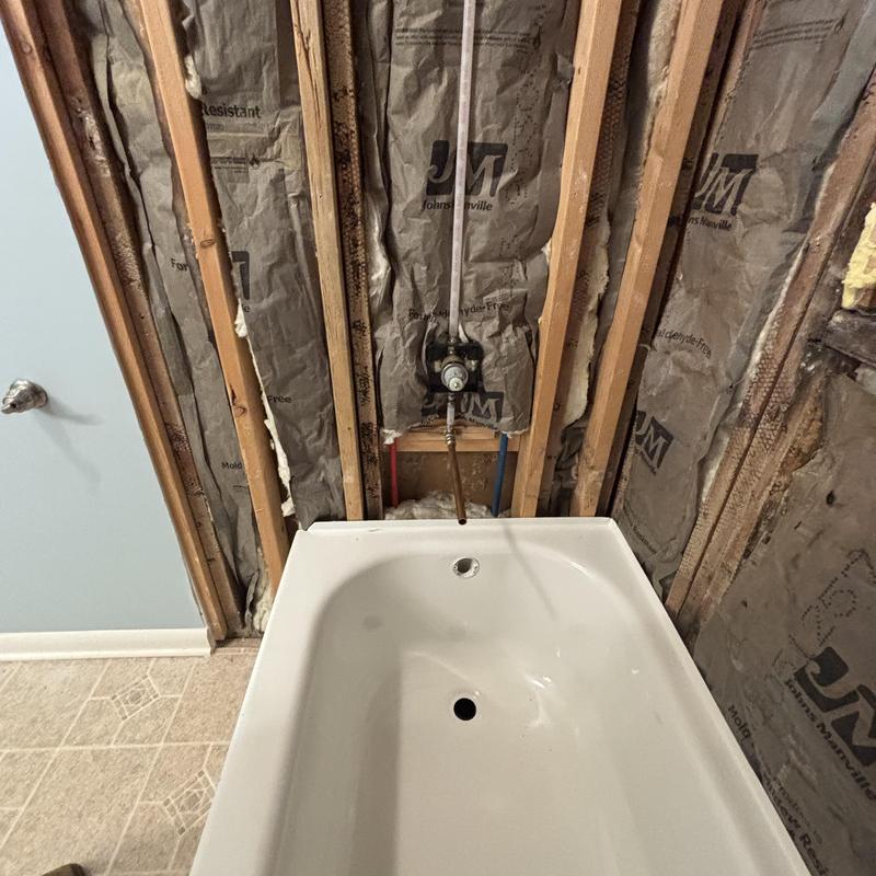 Bathtub installation with exposed shower valve and insulation Bathtub installation with exposed shower valve and insulation