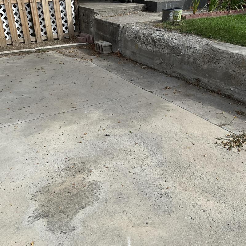 Concrete driveway with surface staining and debris