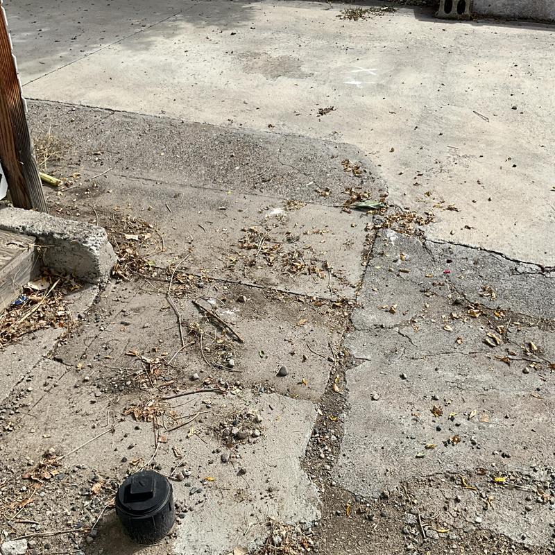 Main sewer cleanout installation on cracked driveway