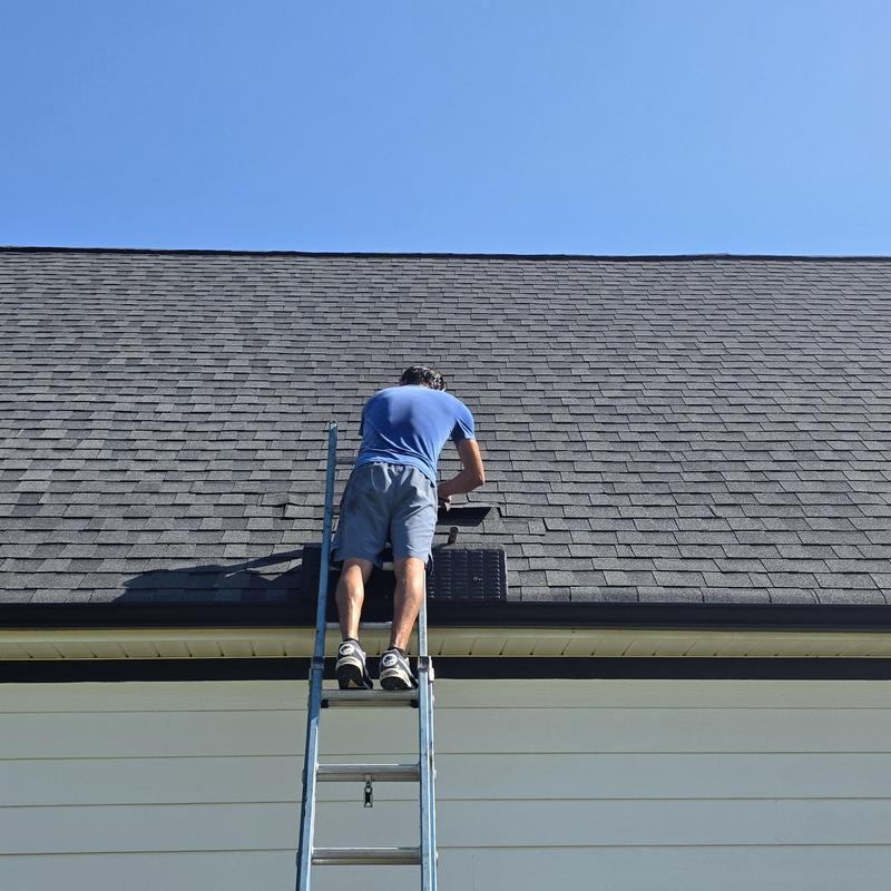 Asphalt shingle roof with hip and ridge repairs on ladder Asphalt shingle roof with hip and ridge repairs on ladder