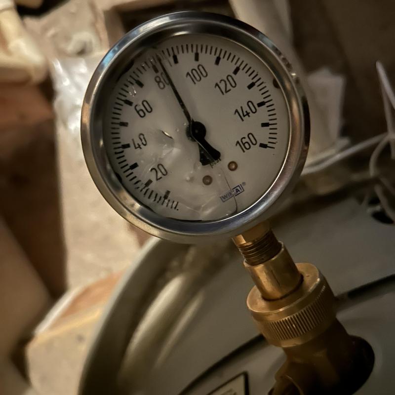 Gas fireplace pressure gauge with cracked glass close-up