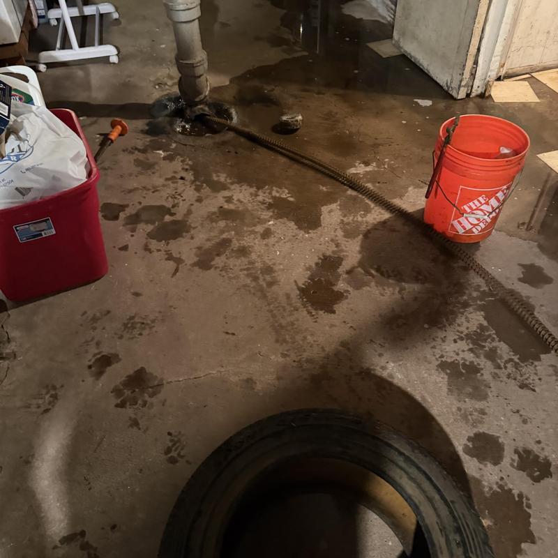 Main sewer line with drain snake and water spill Main sewer line with drain snake and water spill