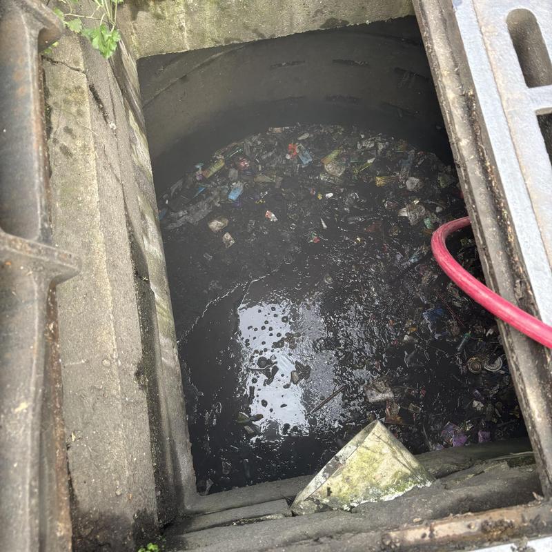 Storm drain catch basin filled with sludge and debris Storm drain catch basin filled with sludge and debris