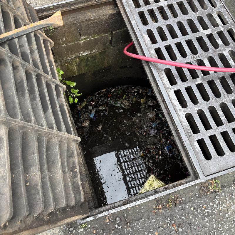 Storm drain catch basin with debris and sludge buildup Storm drain catch basin with debris and sludge buildup