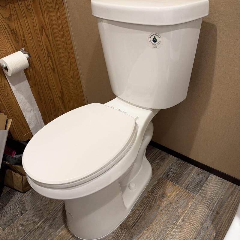 Toilet with closed lid in bathroom corner