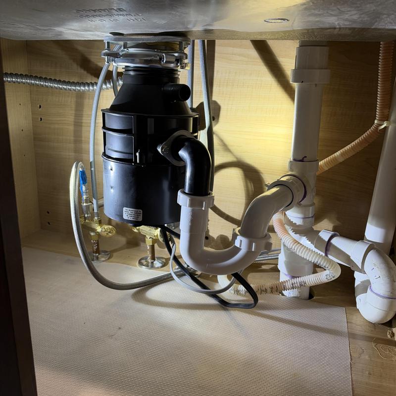 Garbage disposal with attached plumbing and drain pipes