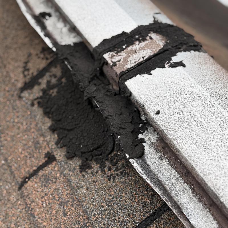 Roof cement patching on asphalt shingle roof edge Roof cement patching on asphalt shingle roof edge