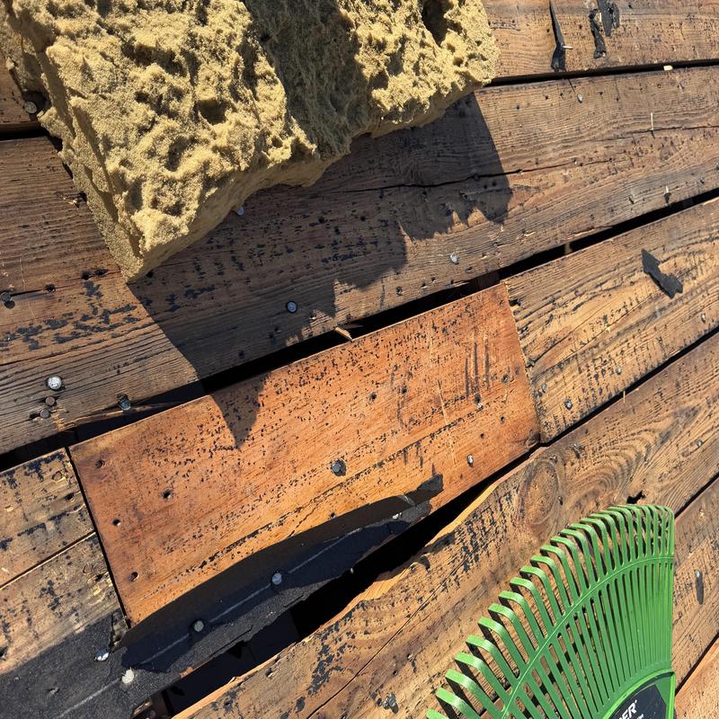 Wood plank roof decking with gaps and repairs Wood plank roof decking with gaps and repairs