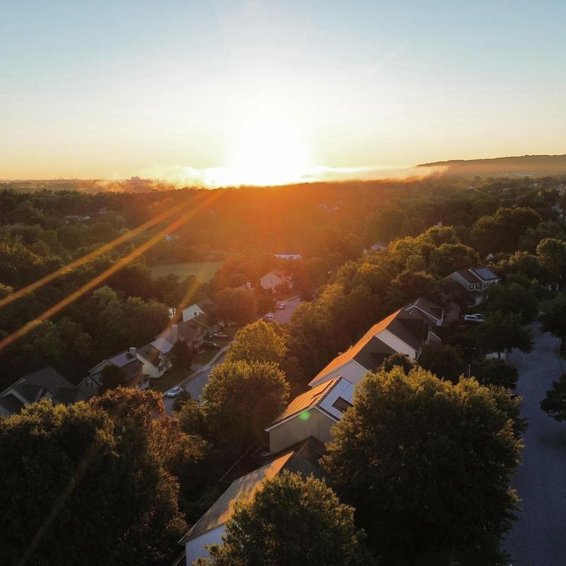 Residential roofs with new architectural shingles at sunset Residential roofs with new architectural shingles at sunset
