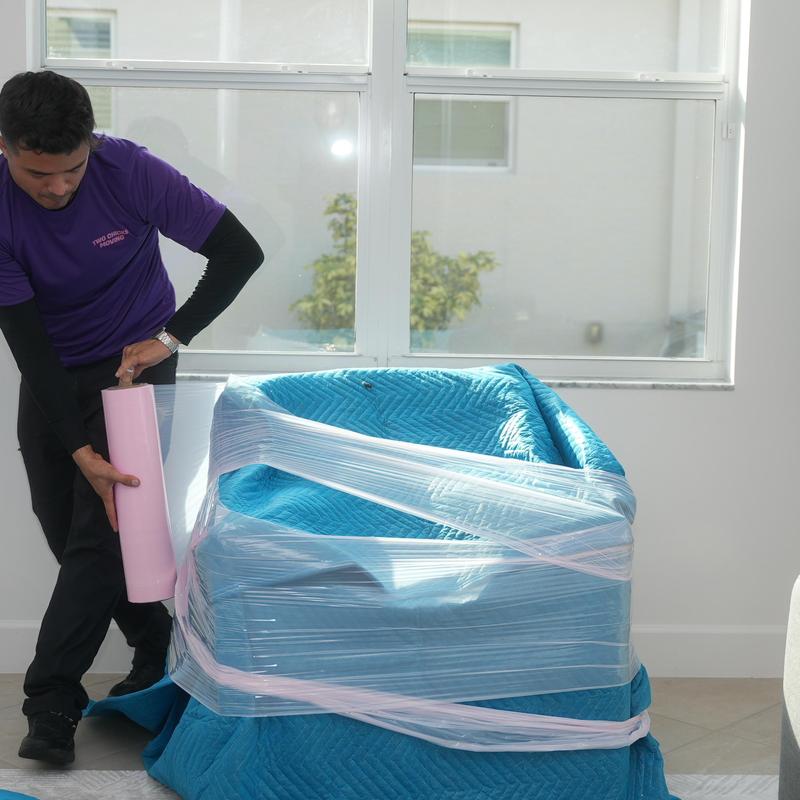 Armchair wrapped in moving blanket and plastic wrap