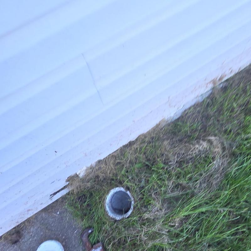 Main sewer cleanout with access pipe in grass and concrete Main sewer cleanout with access pipe in grass and concrete