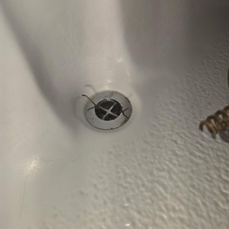 Tub drain with plumbing cable in white bathtub Tub drain with plumbing cable in white bathtub