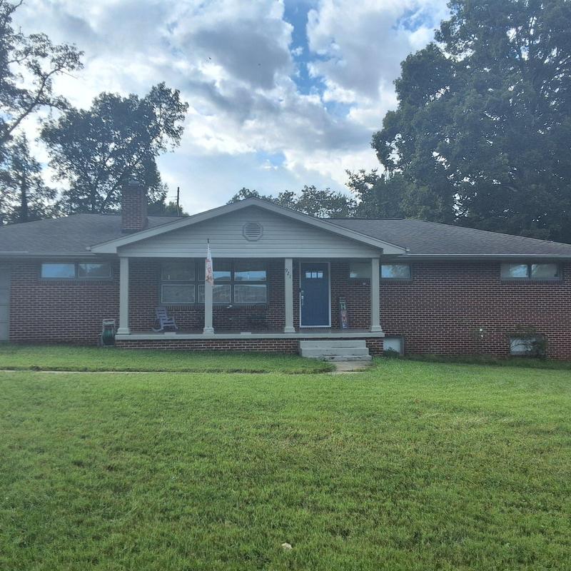 Asphalt shingle roof on brick home with front porch