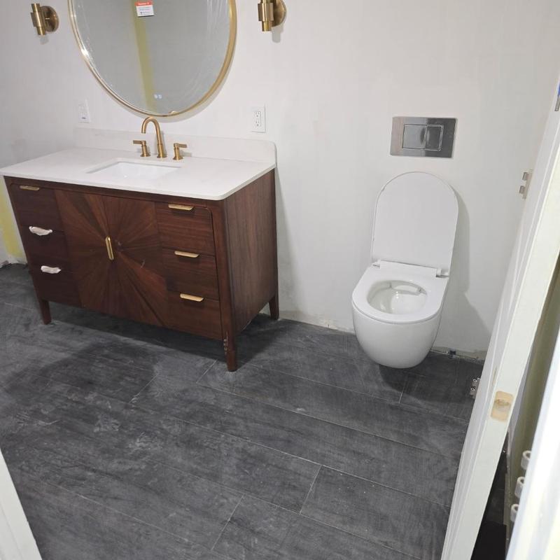 Wall-mounted toilet and wooden vanity bathroom setup Wall-mounted toilet and wooden vanity bathroom setup