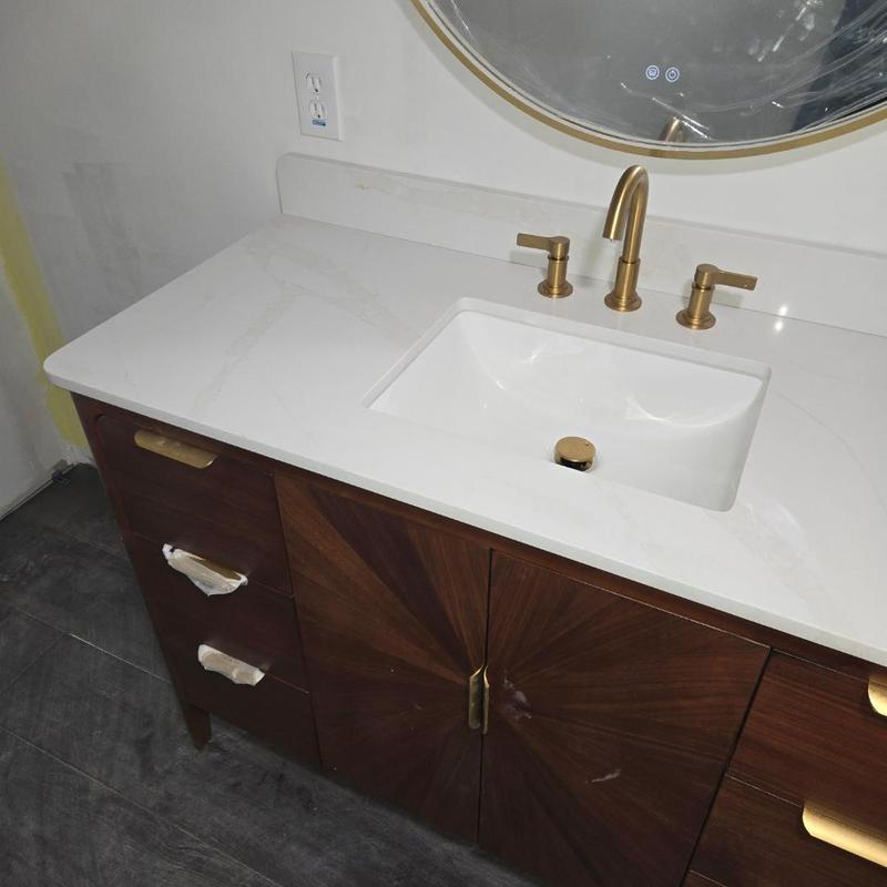 Bathroom sink with gold faucet and wood vanity Bathroom sink with gold faucet and wood vanity