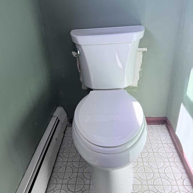 Toilet with Kohler tank installed in bathroom corner Toilet with Kohler tank installed in bathroom corner
