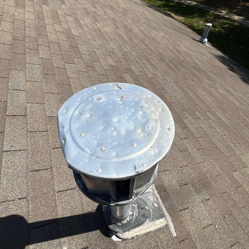 Vent pipe cap with hail damage on shingle roof