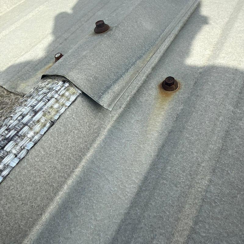 Metal roof panel with rusted fasteners and exposed sealant strip