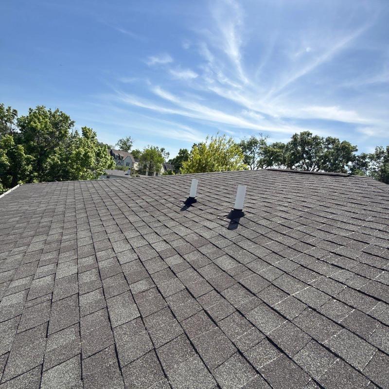 Asphalt shingle roof with vent pipes and hail damage marks