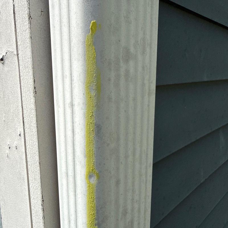 Vinyl siding trim with yellow marked damage spot