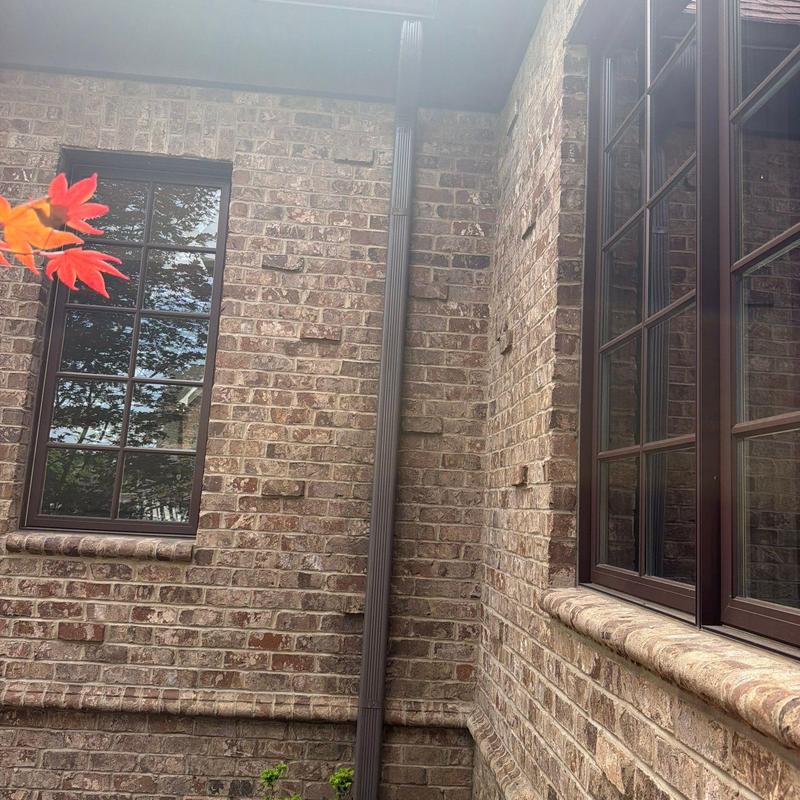 Brick wall and downspout gutter system on house exterior