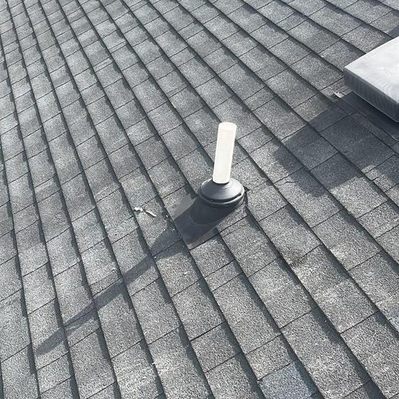 Shingle roof with vent pipe flashing and sealant