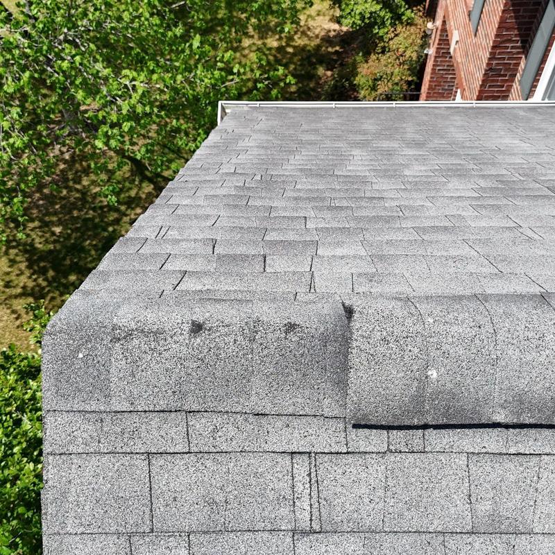 Asphalt shingle roof with visible hail damage on edge