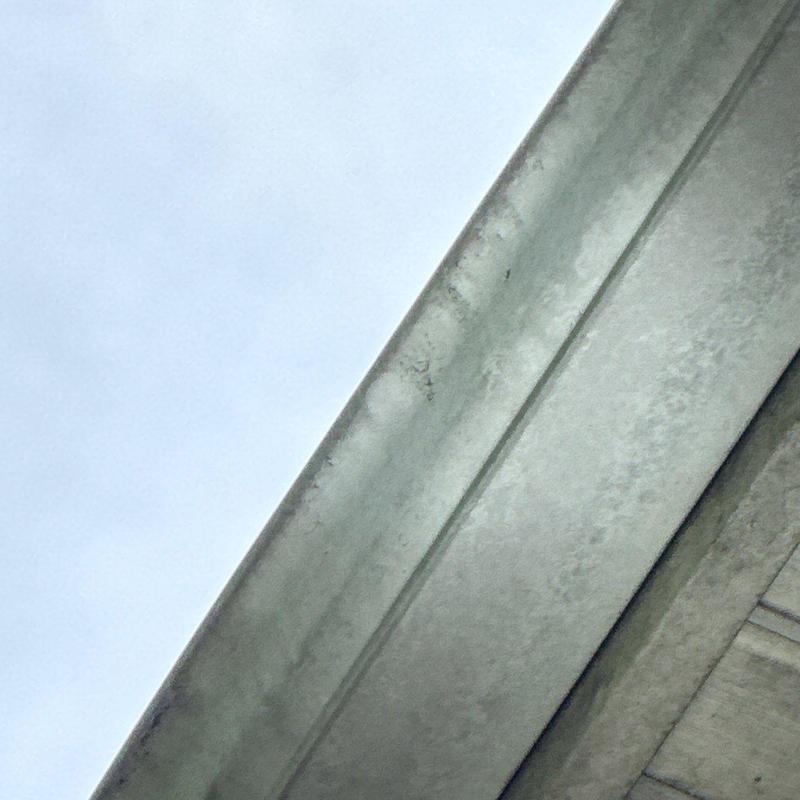Metal gutter showing signs of hail damage